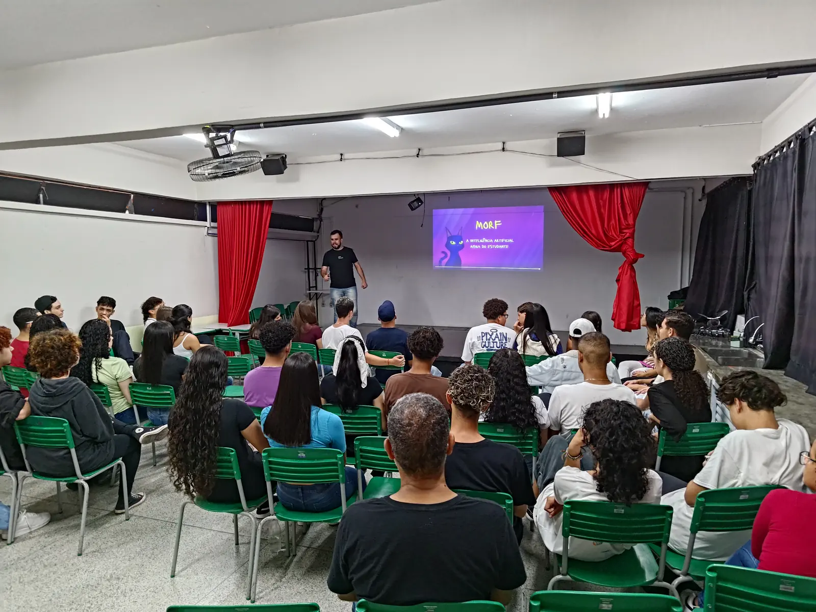 Auditório cheio de estudantes com slide MORF, a inteligência artificial para os estudantes